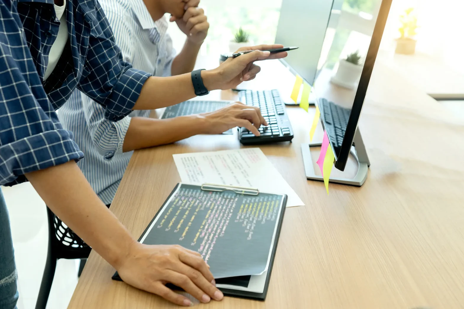 two people sitting at a table with laptops creating a website